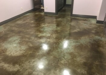Interior acid stained concrete floor in a commercial space, showing a polished, mottled finish. Finished interior concrete floor with acid stain in a commercial space.