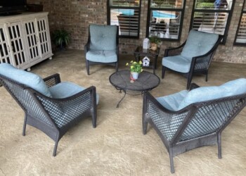 Comfortable outdoor seating with four blue cushioned chairs and a small table. Outdoor seating area with four blue cushioned chairs and a round table.
