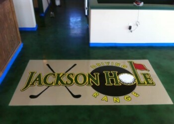 Jackson Hole Range logo on a floor mat at a golf facility. Jackson Hole Range logo on a floor mat with golf clubs and a golf ball.