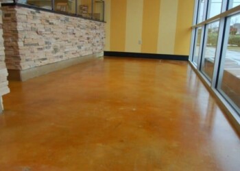 Finished polished concrete floor in a commercial building in Ephrata, PA. Polished concrete floor in a commercial space with large windows and stone accent wall.