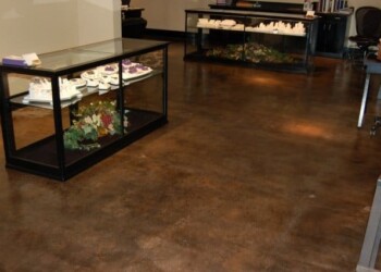 Polished concrete flooring in a commercial office or retail space. Polished concrete floor in a commercial space with display cases and office furniture.