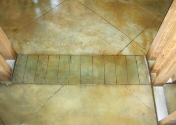 Concrete floor with acid stain finish in a residential interior, showing color variation and sealing. Close-up of a concrete floor with acid stain finish in a residential interior.