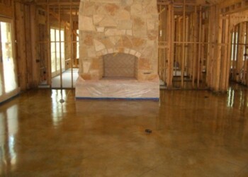 Polished concrete floor and stone fireplace in a house under construction in Eads, Tennessee. Interior of a house under construction with a polished concrete floor and a stone fireplace.